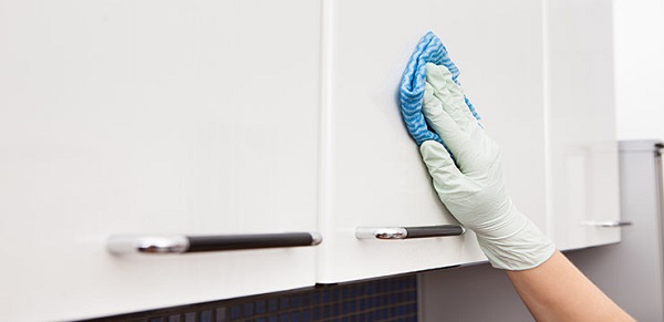 Close-up Of A Woman's Hand Cleaning Cabinet With Cloth